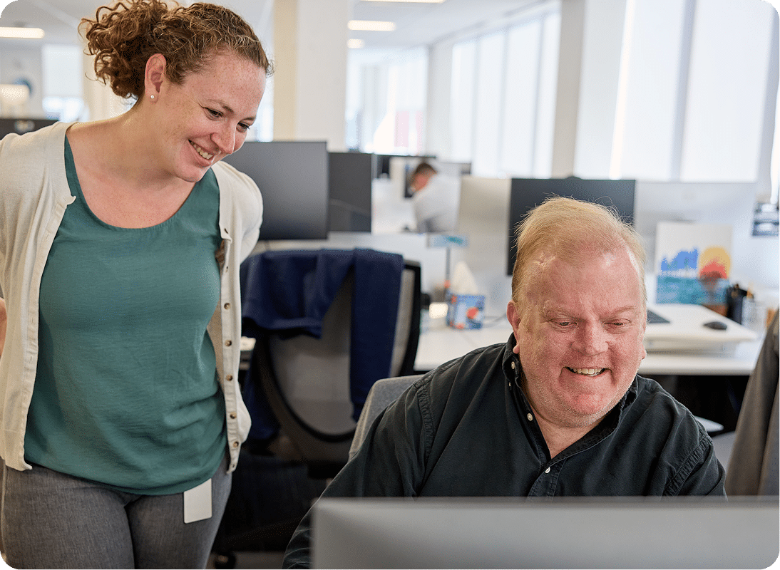 Image of team members in off looking at a computer